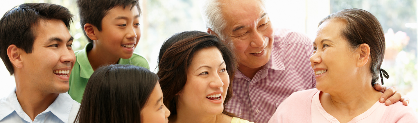 Smiling Asian family looking at grandmother.